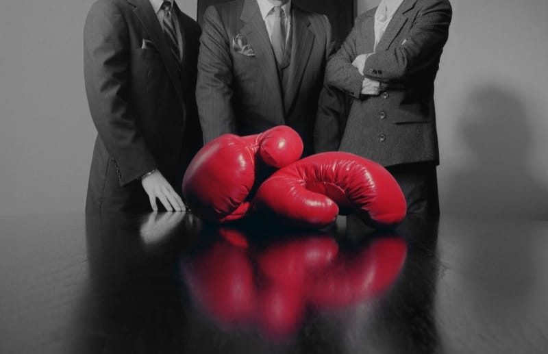 resolving conflict - leadership team coaching. image of boxing gloves on a boardroom table